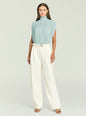 Model wearing Giulia Bodysuit in pale blue with a pleated high neck, paired with ivory wide-leg trousers and belt thumbnail image 5 of 5