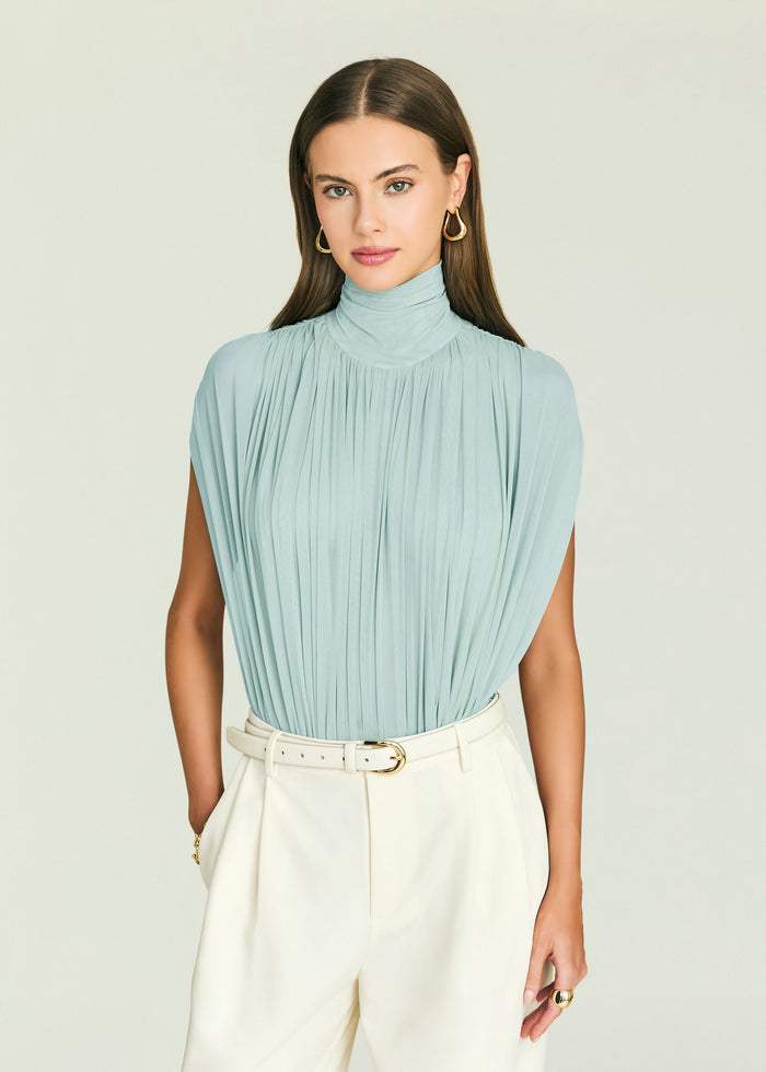 Model wearing a light blue pleated high neck Giulia Bodysuit.