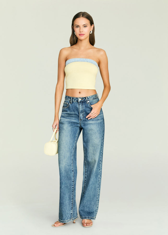 Front view of a model wearing Kiki Knit Top in pale yellow with a light blue denim trim, paired with jeans.