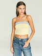 Model in a strapless pale yellow knit top with a light denim band across the bust and jeans. thumbnail image 1 of 5