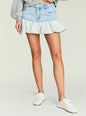 Light wash Mercer Denim Mini Skirt with a grey layered ruffle hem worn with a grey sweatshirt. thumbnail image 1 of 5