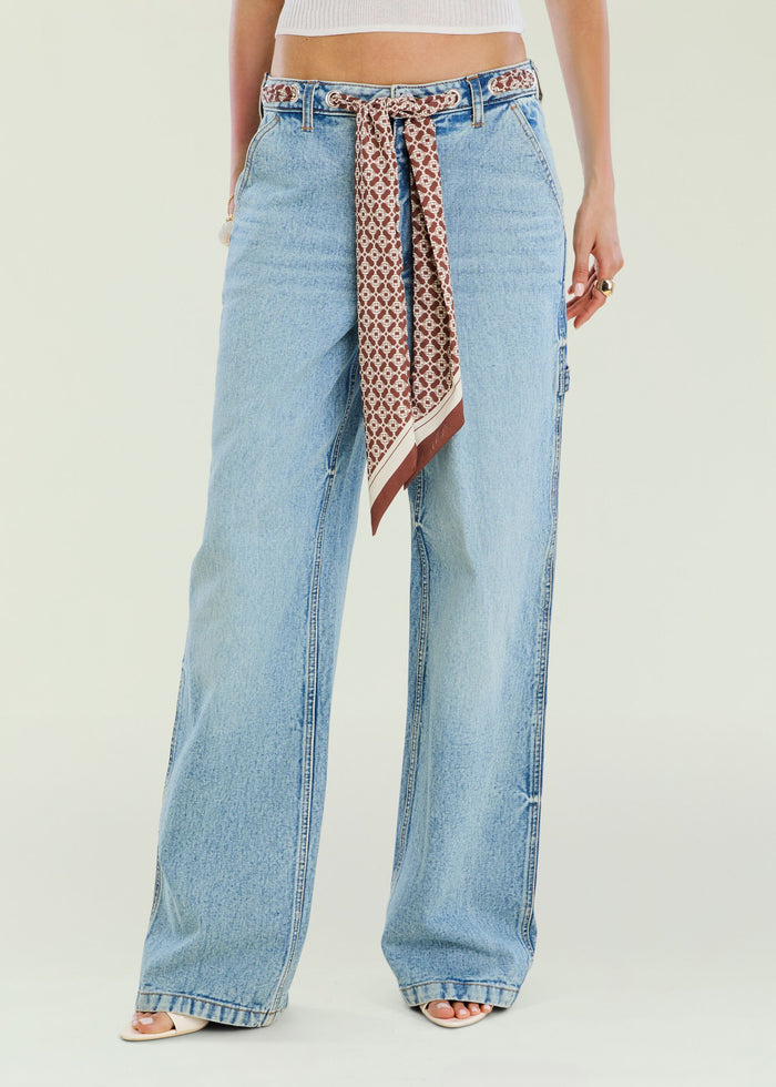 Close up of Bond Denim Pant waist with a printed scarf belt and light wash denim.