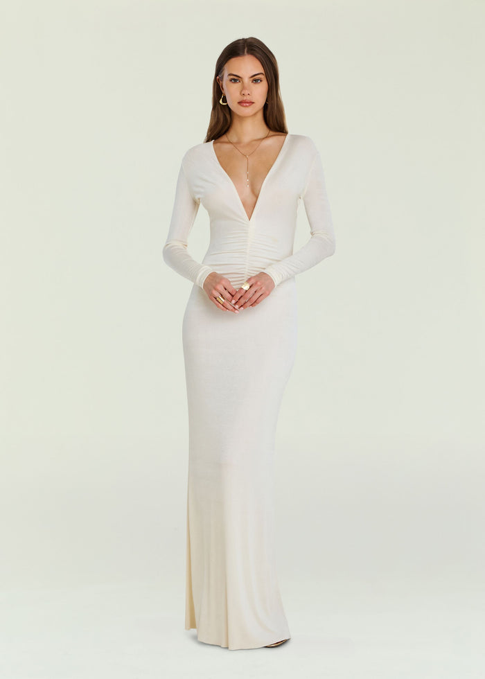 Front view of a model wearing a cream Ebony Maxi Dress with a plunging one shoulder neckline and fitted silhouette