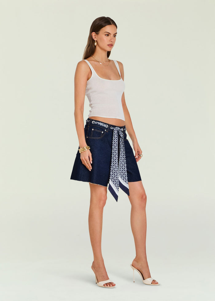 Model wearing Sabrina Boyfriend Shorts with a blue patterned scarf belt over dark denim and a white ribbed tank.