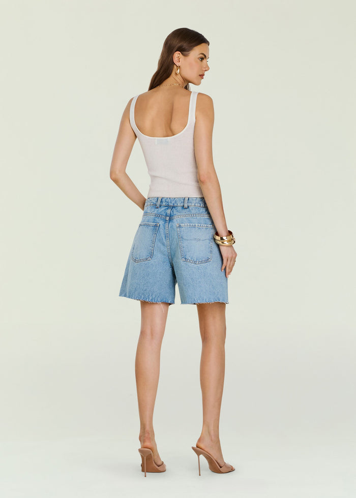 Back view of a model wearing Sabrina Boyfriend Short in light wash denim with a frayed hem