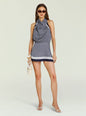 Model wearing Winny Mini Dress with navy and white geometric print halter neckline and draped front thumbnail image 1 of 6