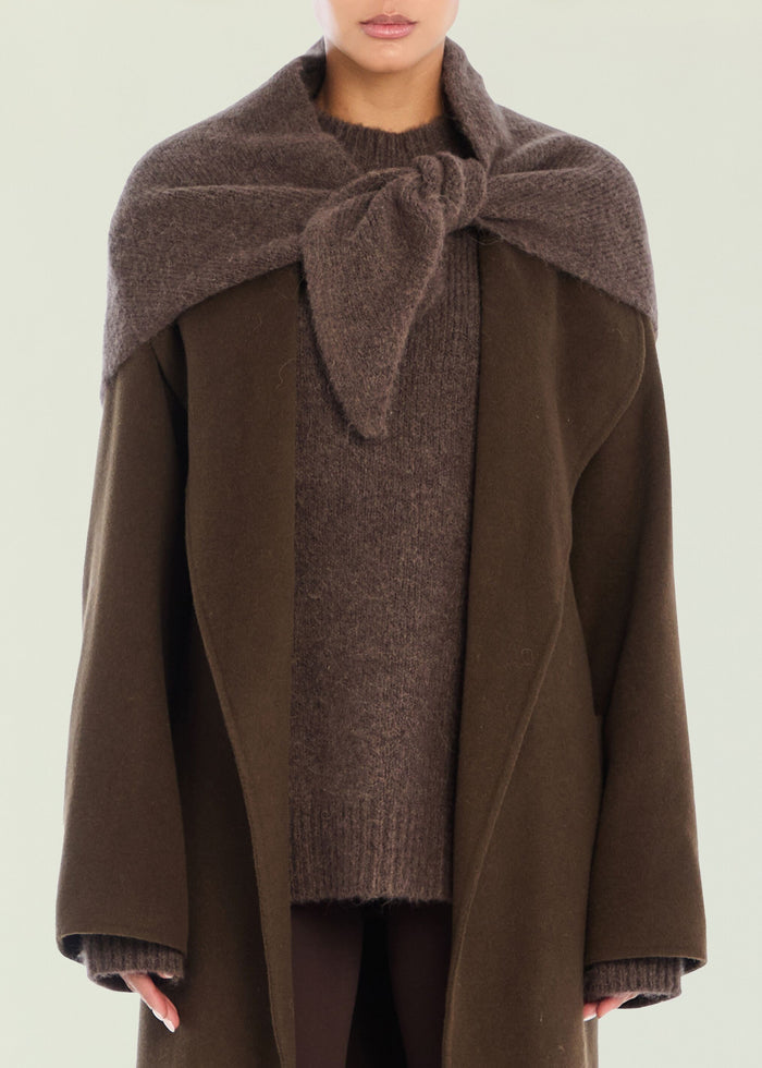 Model wearing the Amelie Scarf draped over shoulders and tied at the front with a brown knit top