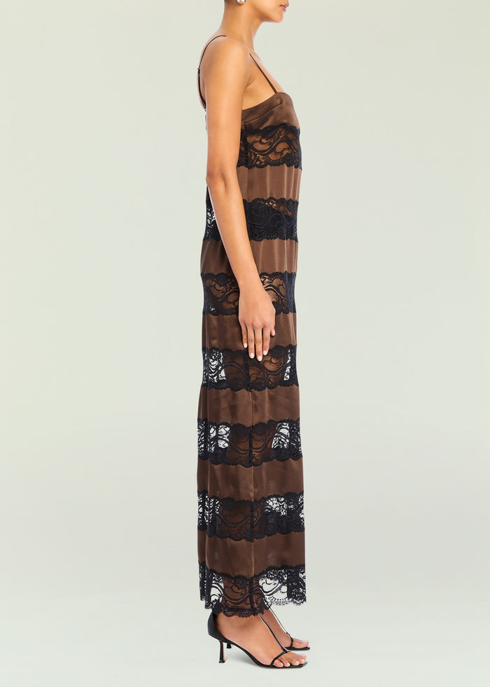 Side view of a model in the Faye Maxi Dress showing brown satin and black lace panels and strappy sandals.