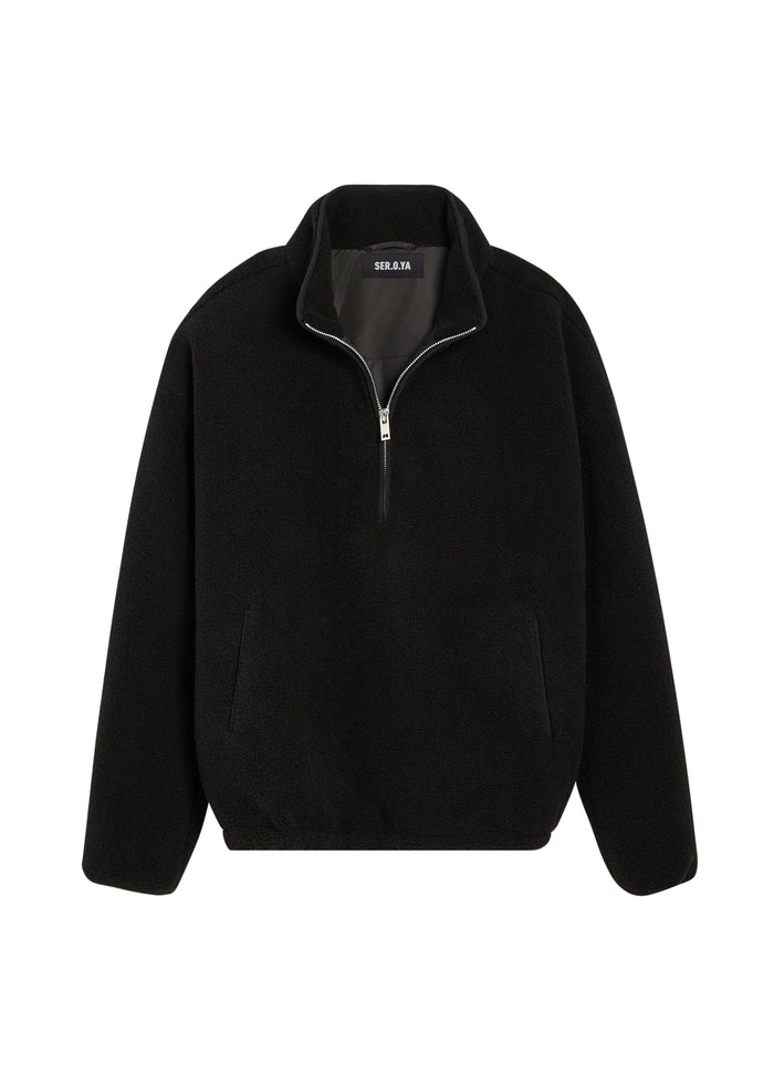 Close up of a black faux shearling zip jacket with a high collar and silver zipper.