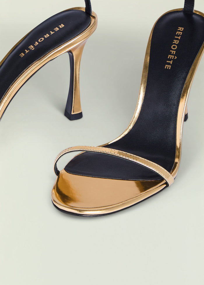 Gold metallic high heel sandal with black footbed and slim ankle strap