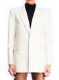 White Acadia blazer on a model worn over a black turtleneck with notched lapels and structured shoulders. thumbnail image 1 of 6