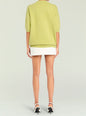 Back view of lime green Jacey Sweater with three quarter length sleeves and ribbed hem over a white skirt thumbnail image 5 of 5