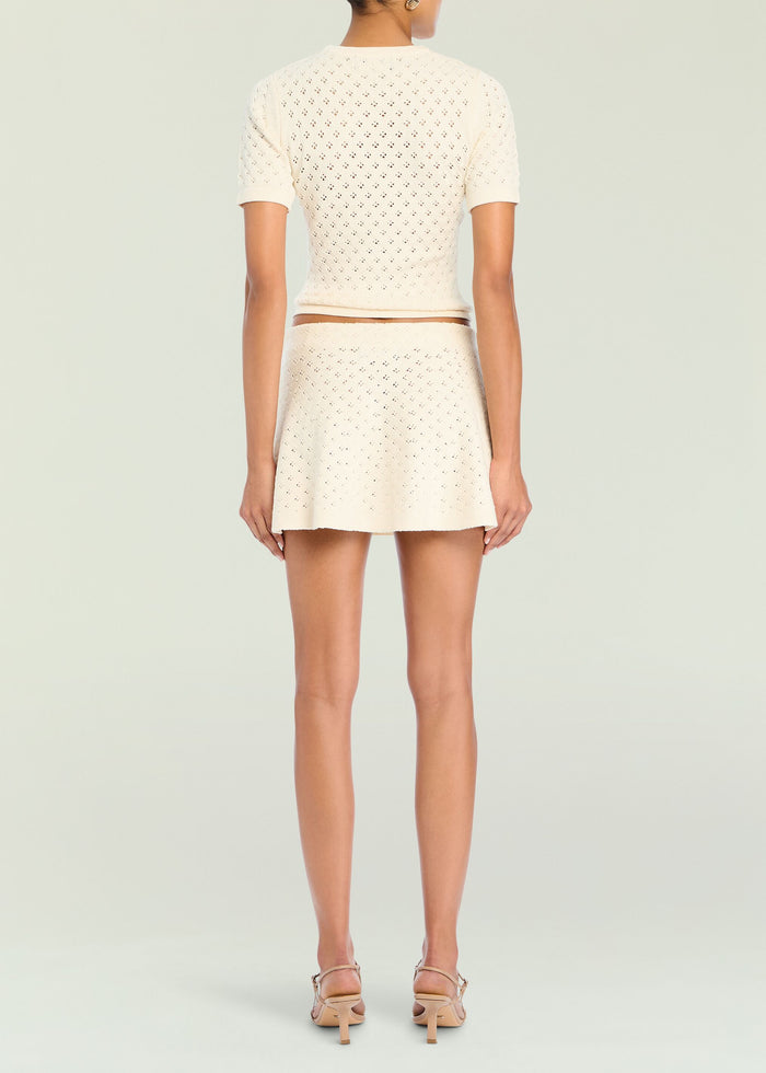 Back view of a model wearing the Josie Pointelle Knit Top with matching cream skirt