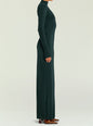 Side view of a model in a dark green velvet Kim Maxi Dress with long sleeves and high neck, paired with brown heels. thumbnail image 3 of 5