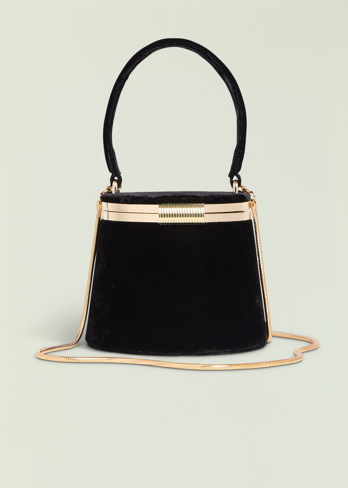 Lesla Case black velvet handbag with curved top handle and gold hardware.