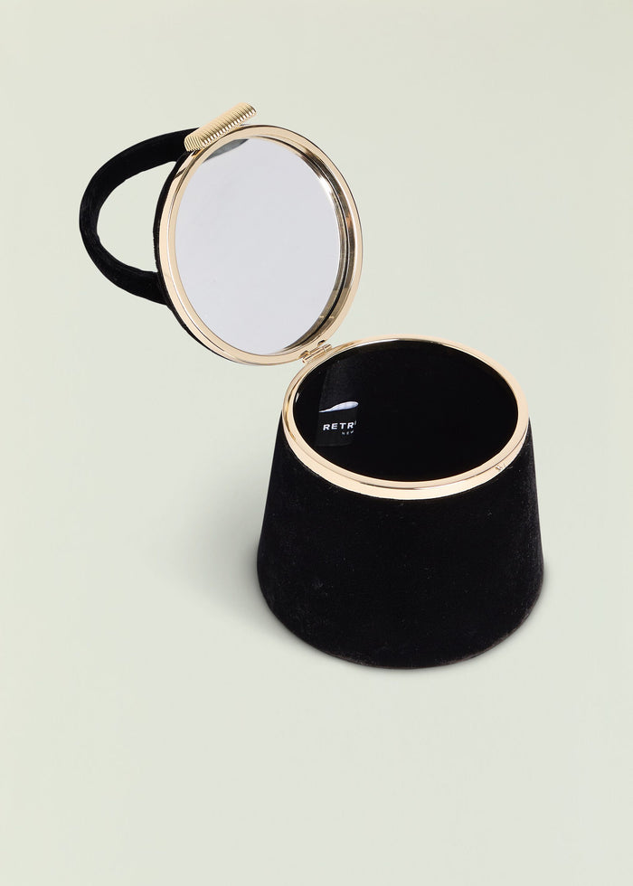 Lesla Case gold round compact mirror open on a black display stand
