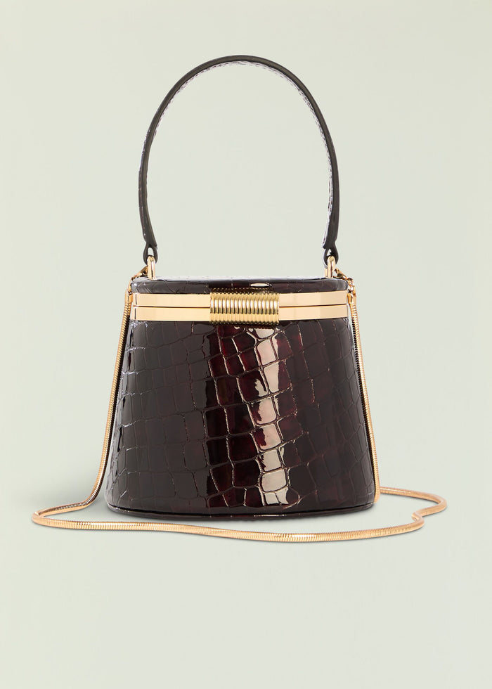 Lesla Case opened to reveal round mirror inside a dark crocodile-embossed exterior with gold hardware