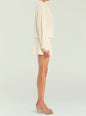 Side view of a model wearing an ivory pointelle knit pullover with matching knit shorts and strappy sandals. thumbnail image 3 of 5
