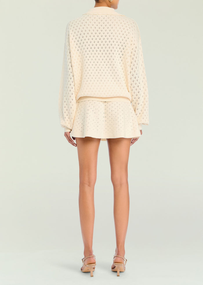 Back view of ivory pointelle knit pullover with relaxed fit and ribbed hem over matching knit shorts.