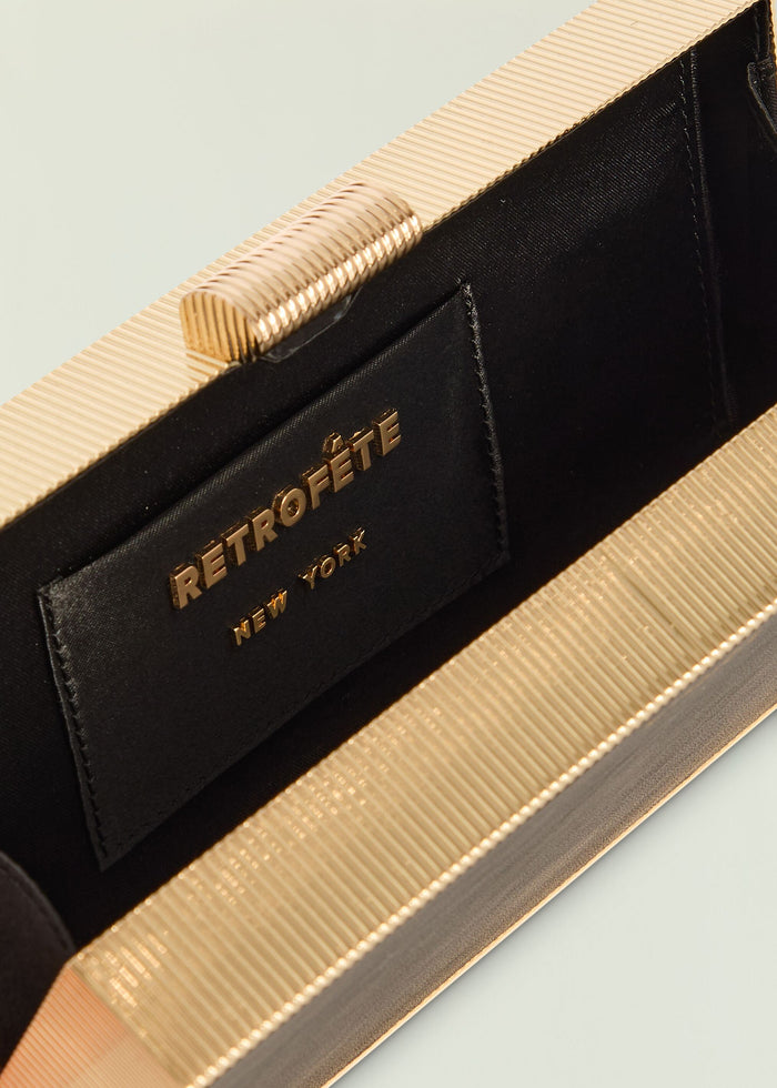 Milo Clutch with gold ribbed top frame and black crocodile textured body