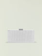 Milo Clutch in silver ribbed metal with a small curved clasp on top against a pale background. thumbnail image 1 of 3