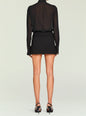 Back view of a model wearing a black sheer long sleeve blouse and a black mini skirt with a belt thumbnail image 5 of 5