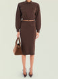 Model wearing a chocolate brown cropped knit top with a matching midi skirt and front pockets, carrying a brown suede bag. thumbnail image 2 of 5