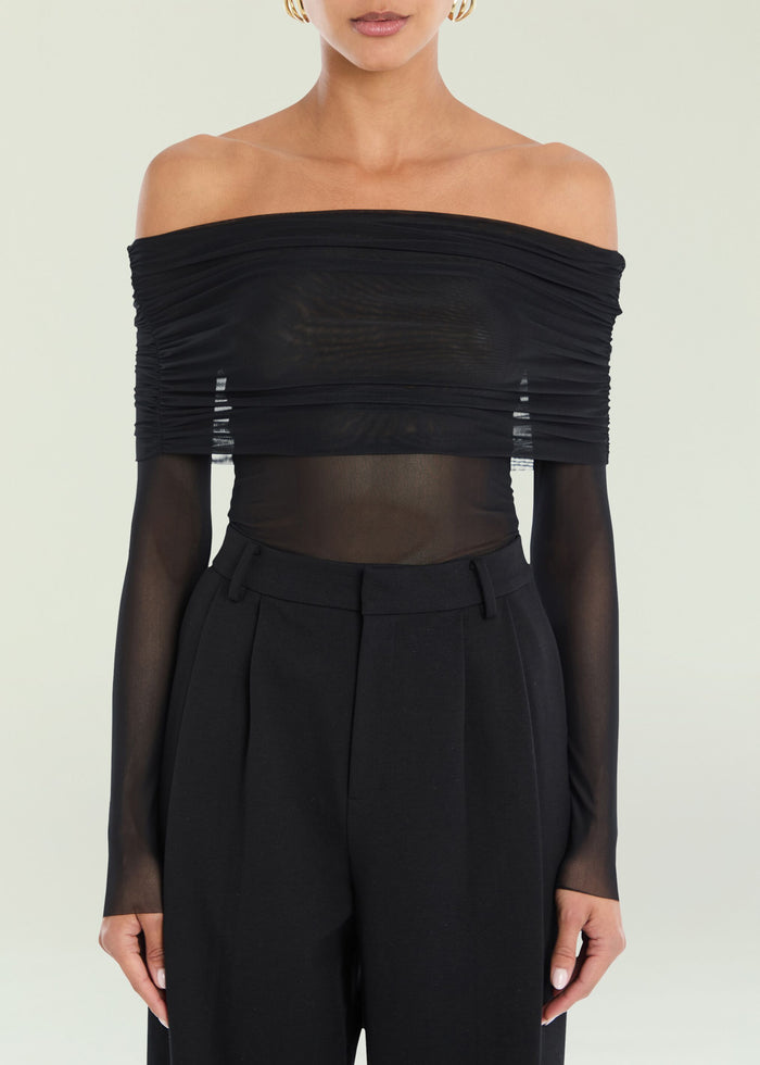 Rosa Top off shoulder black ruched bodice with sheer long sleeves on the model