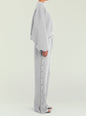 Side view of a model wearing a grey Calla Sweatshirt with matching pants and metal snap buttons along the leg thumbnail image 3 of 5