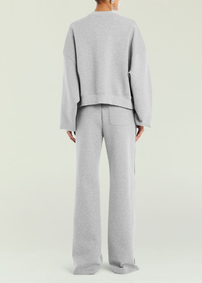Back view of Calla Sweatshirt in heather gray with a curved hem over matching pants