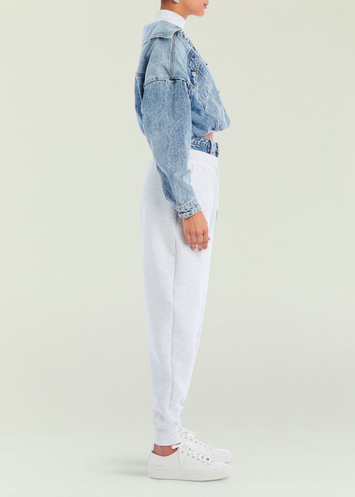Side view of a model wearing a light blue denim jacket over a white top and gray Klara Sweatpant