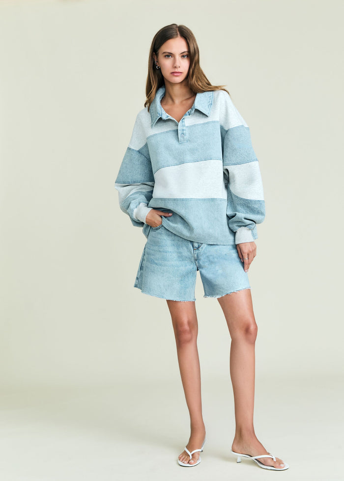 Model wearing Cher Denim Top in light blue color-block polo style with a collar, paired with denim shorts