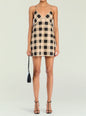 Model in a beige and black gingham linen mini dress with thin straps and a V neckline. thumbnail image 1 of 5
