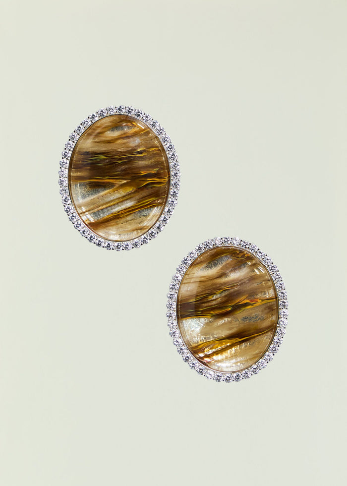Large amber oval stone earring surrounded by a halo of clear crystals.