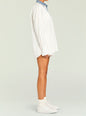 Side view of white Gill Oversized Shirt with denim collar paired with white shorts and sneakers thumbnail image 4 of 5