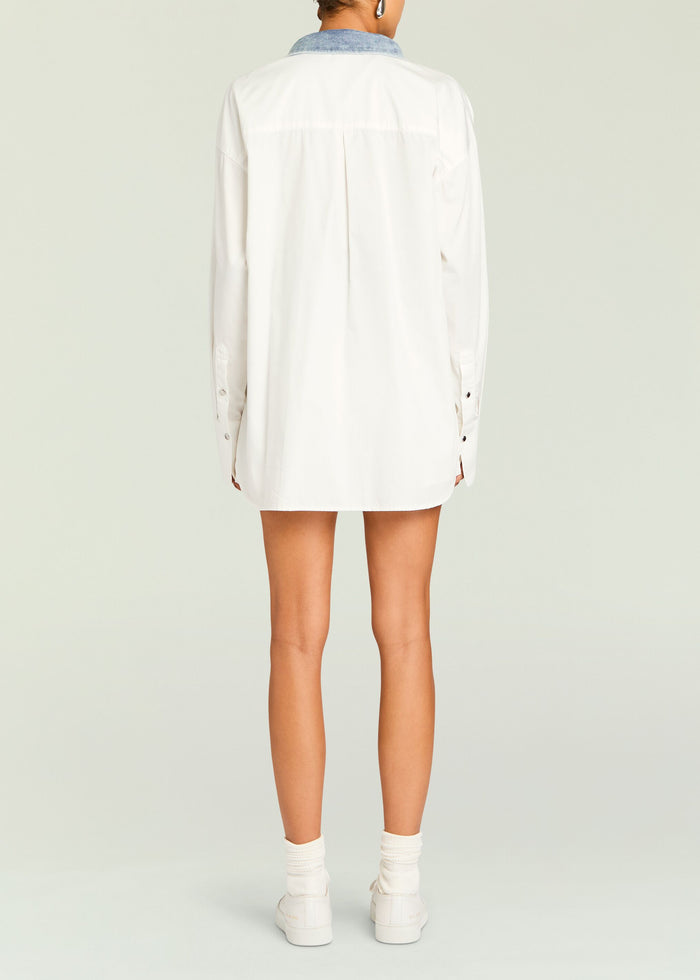 Back view of an oversized white shirt with a blue denim collar and center back pleat.