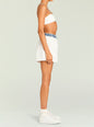 Profile view of a model wearing Tama Boxer Short in white with a blue denim elastic waistband. thumbnail image 3 of 5