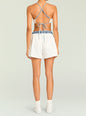 Back view of a model wearing Tama Boxer Short in white with a denim waistband and crisscross back straps. thumbnail image 4 of 5
