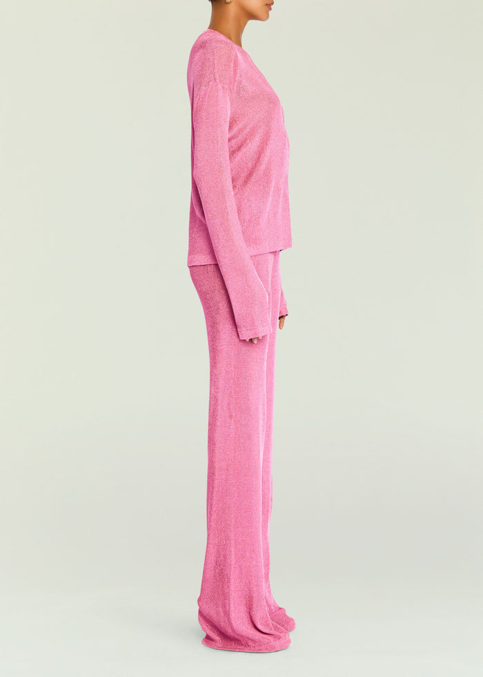 Side profile of a pink metallic knit top with matching pants on a model