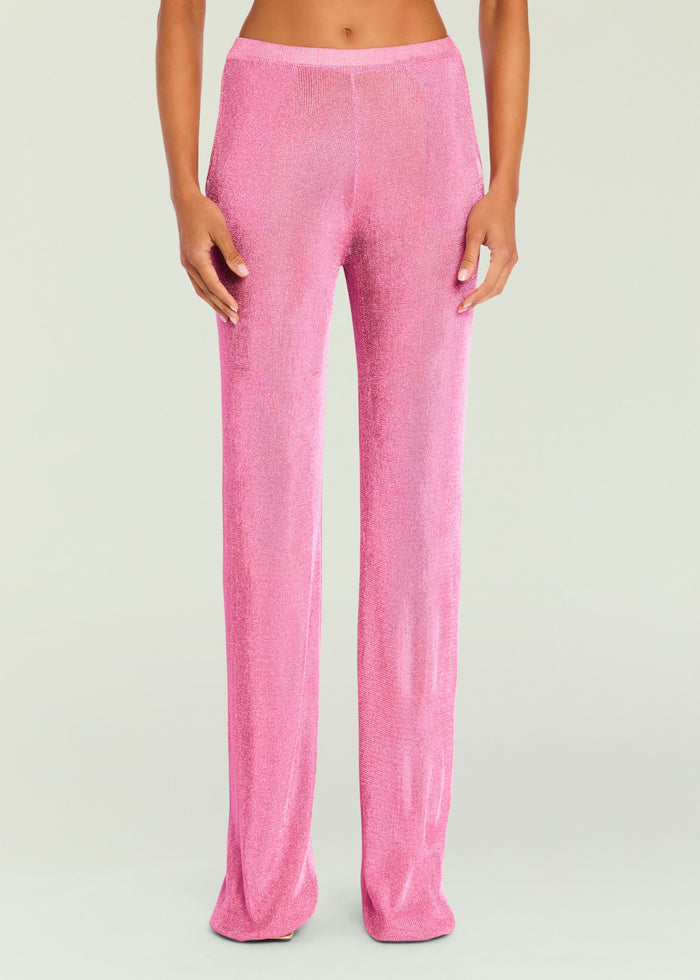Bright pink metallic knit pants on a model, shown from waist to ankles