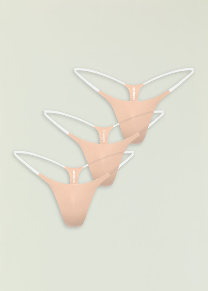 Three peach seamless thong panties with white straps stacked in a vertical display