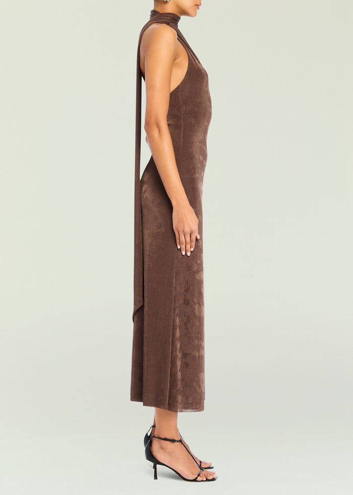 Side view of brown velvet Tre Midi Dress showing a halter neck and a long fabric tie draping down the back