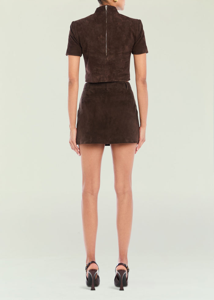 Back view of a brown suede short-sleeve top with a vertical center zipper.
