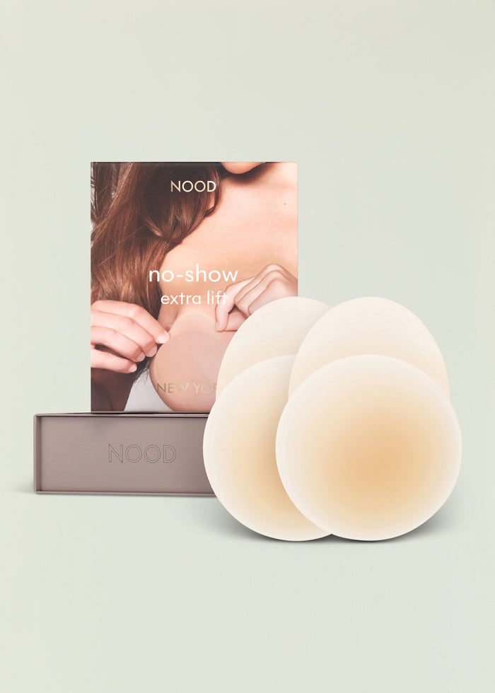NOOD no show extra lift packaging with multiple white silicone nipple covers fanned beside the box.