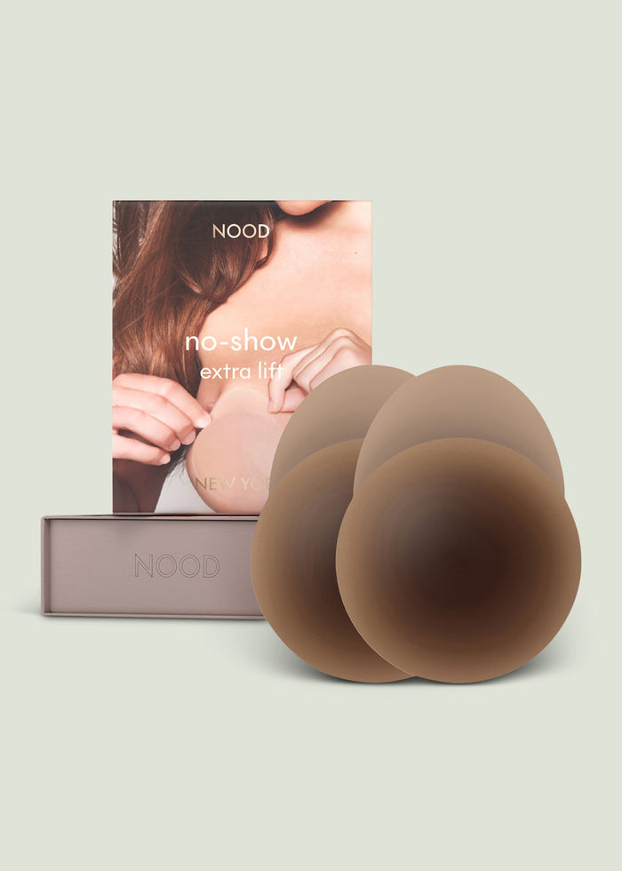 NOOD shape tape breast tape packaging with a model in brown attire and stacked beige rolls