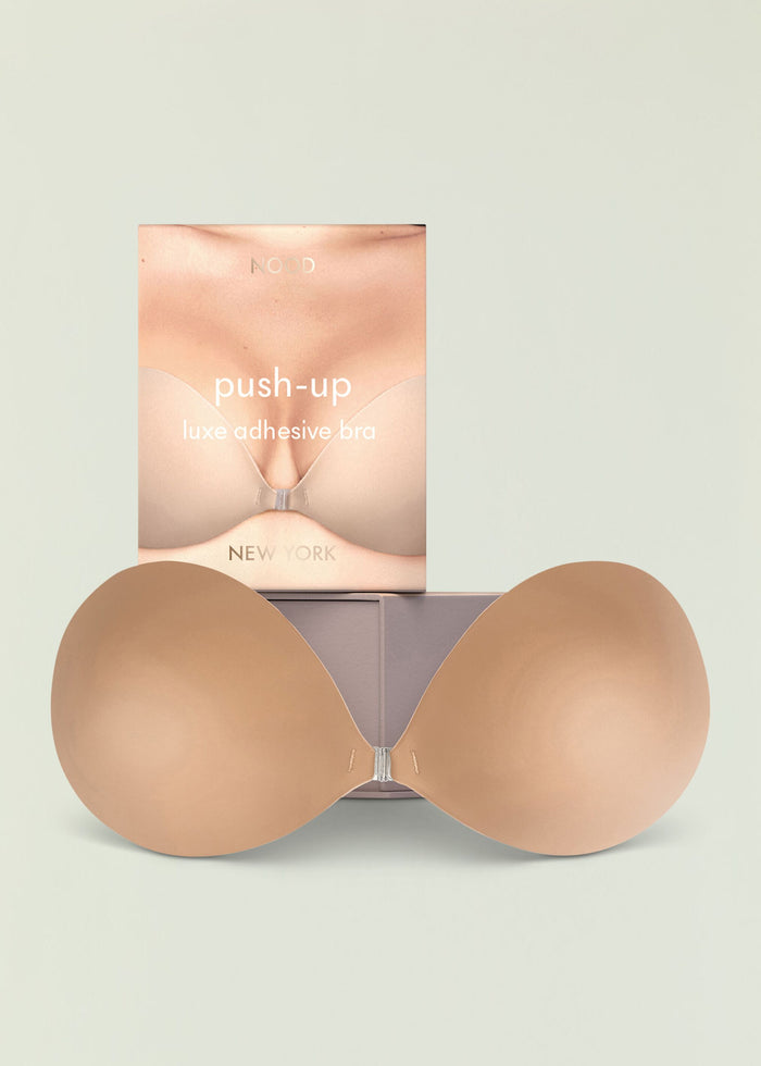 Push up luxe adhesive bra packaging with large beige bra cups arranged around the box