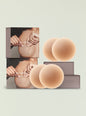 Stacked NOOD packaging beside large nude silicone nipple covers on a pale backdrop. thumbnail image 1 of 2