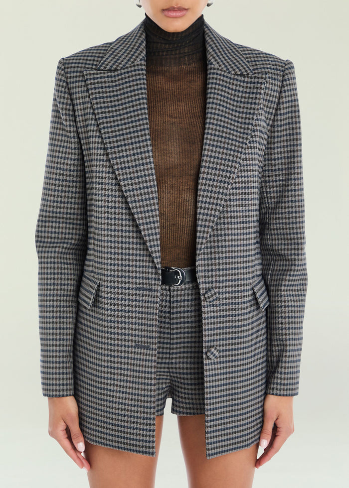 Front view of the Walter blazer in gray and black houndstooth worn with a brown turtleneck.