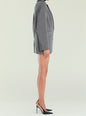 Side view of the Walter blazer on a model, a long checkered coat with a waist belt. thumbnail image 3 of 5