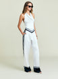 Full-length model wearing Nicola Top white halter with navy chevron belt and matching striped wide-leg pants, sunglasses thumbnail image 4 of 6